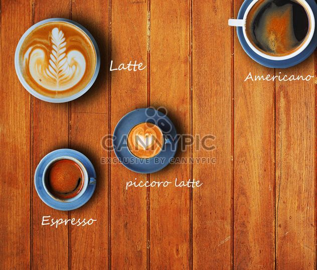 Cups of different coffee on wooden background - бесплатный image #186959