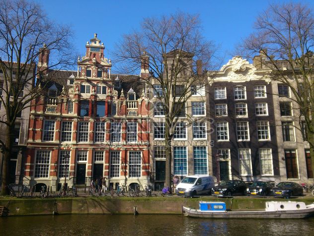 Dutch houses by the canal in Amsterdam - image #200339 gratis
