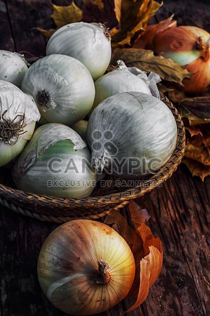 Onions in basket and on wooden background - бесплатный image #302029