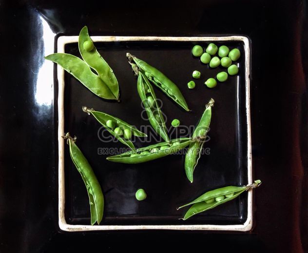 Green peas on black plate - бесплатный image #342589