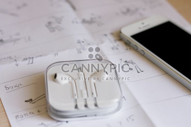Closeup of smartphone and earphones on paper - Free image #345049