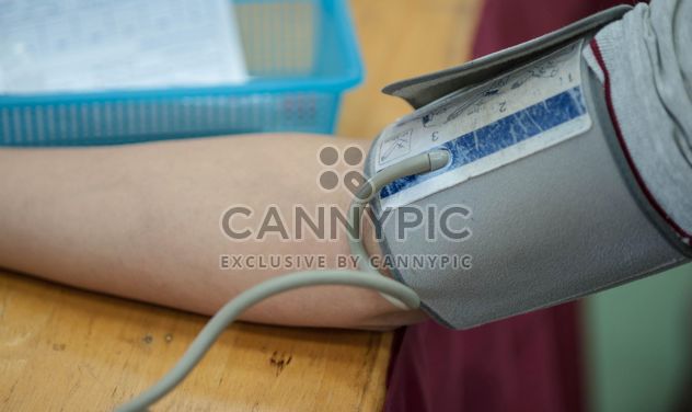 Person checking blood pressure at table - image #347259 gratis