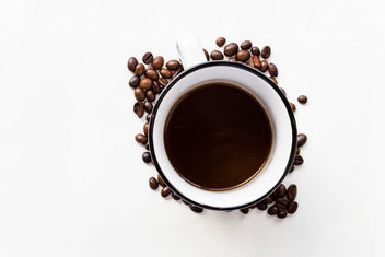 A cup of black coffee and coffee beans - image #449069 gratis