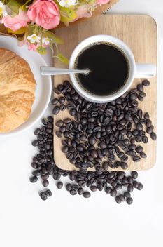 Cup of coffee with croissant, flowers and coffee beans - бесплатный image #452569