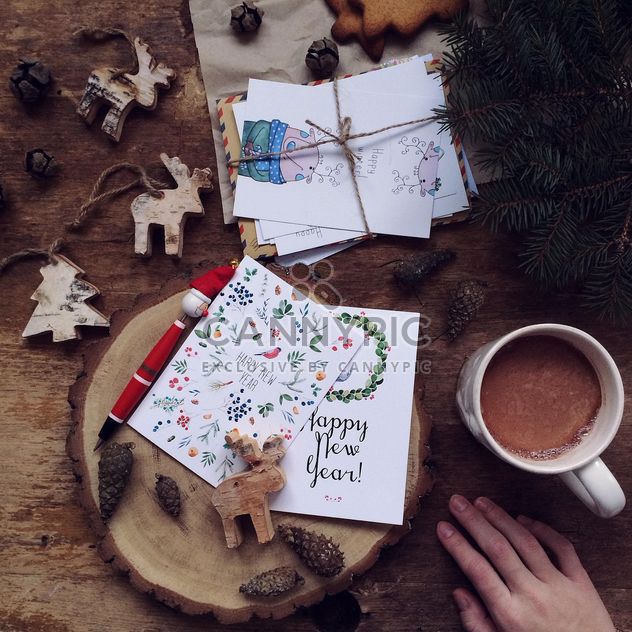 Toy deers, fir tree, New Year cards and cup of coffee over wooden background - бесплатный image #136279