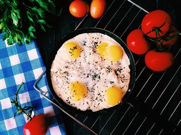 Fried eggs, tomatoes and parsley on table - бесплатный image #136509