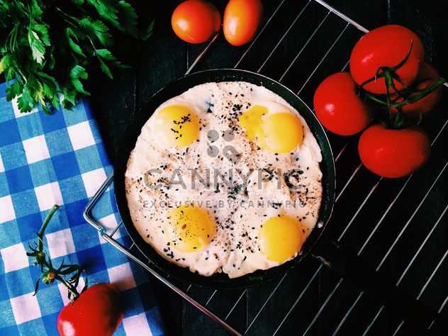 Fried eggs, tomatoes and parsley on table - бесплатный image #136509