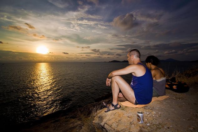 Couple sitting on ocean coast - image #183419 gratis