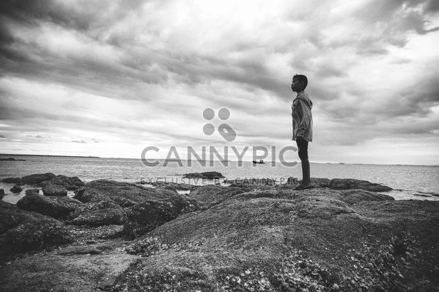 Boy standing on rocks - image #185649 gratis