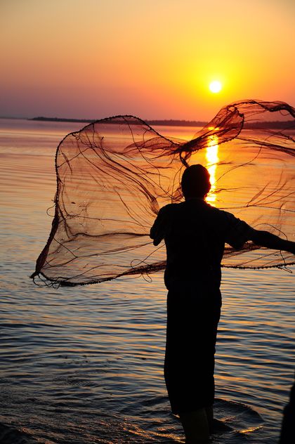 a fisherman throwing net through the sea #sunset - Free image #185769