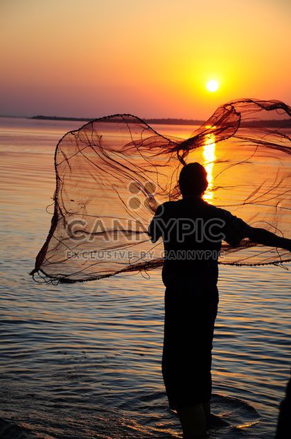 a fisherman throwing net through the sea #sunset - image #185769 gratis