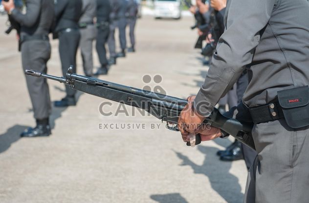 Close-up of policeman hands with gun - image #186299 gratis