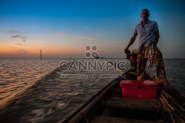 Fisherman in boat on sea at sunset - image #186589 gratis