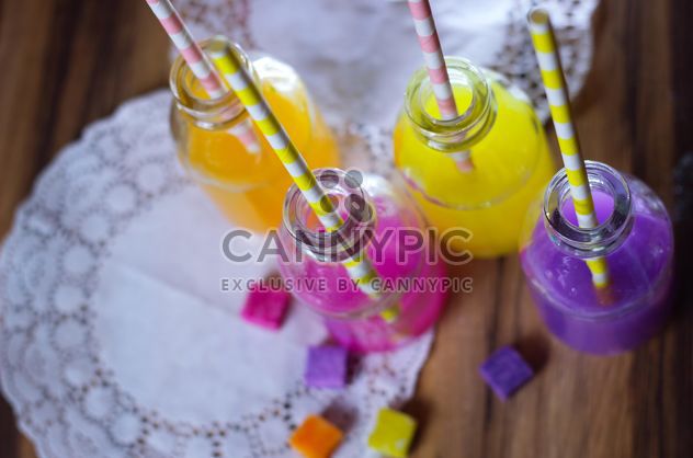Bottles of colorful drinks - image #187619 gratis