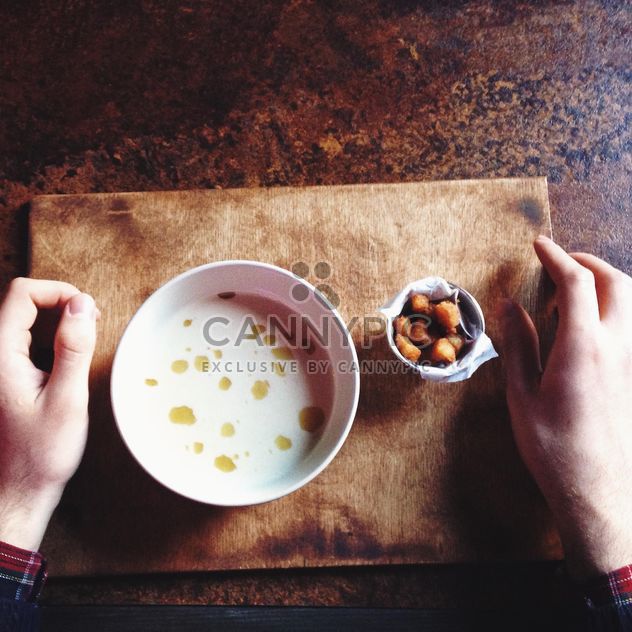 Human hands and bowl of soup on table - бесплатный image #198499
