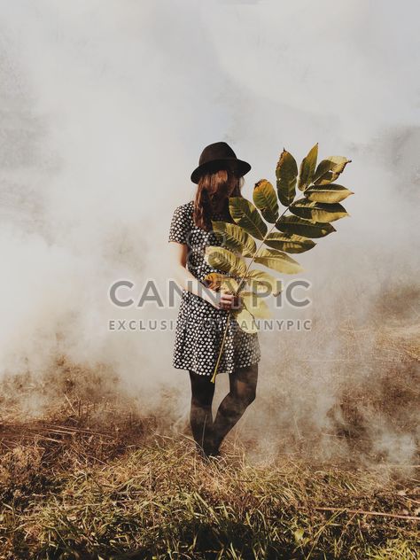 Girl holding branch with big leaves in misty forest - бесплатный image #271719