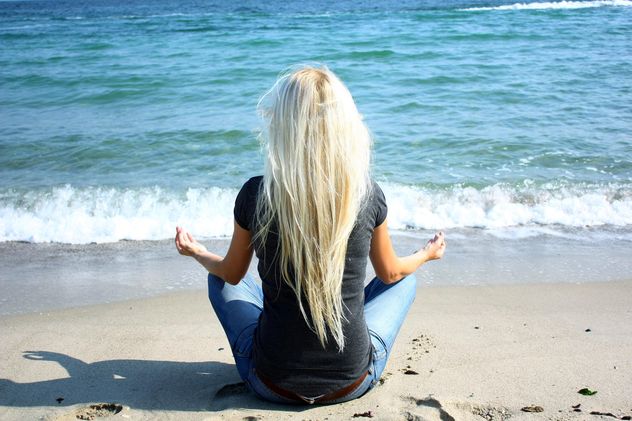 Blond girl meditating on a beach - image gratuit #273939 