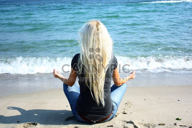 Blond girl meditating on a beach - image #273939 gratis