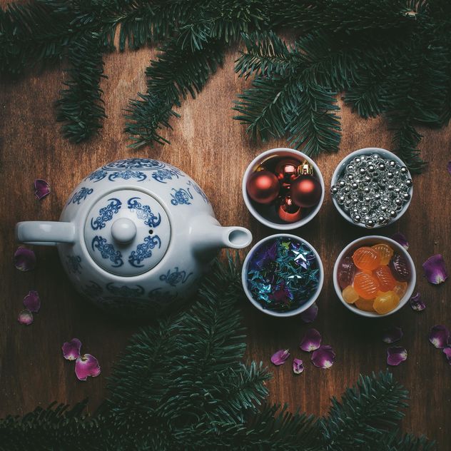 Teapot and Christmas decorations on wooden background - бесплатный image #303949