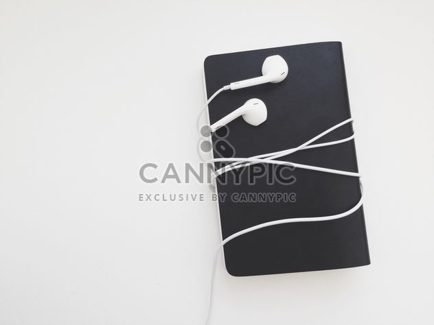 Notebook and earphones isolated on white background - Free image #304109