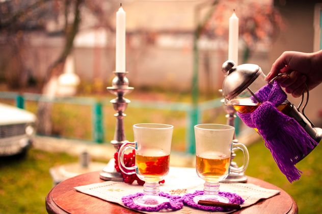 warm tea with cinnamon candles in candlesticks on the table outdoors - image gratuit #327279 