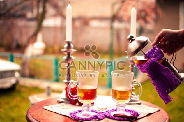 warm tea with cinnamon candles in candlesticks on the table outdoors - бесплатный image #327279