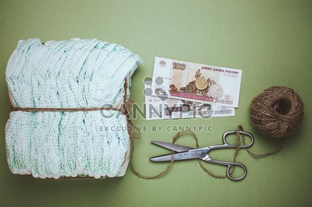Diapers, skein of thread and scissors on green background. Diapers for 3 dollars, Cheboksary, Russia - Free image #342559