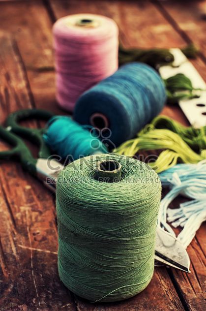 Scissors and colored sewing thread on wooden table - image #343559 gratis