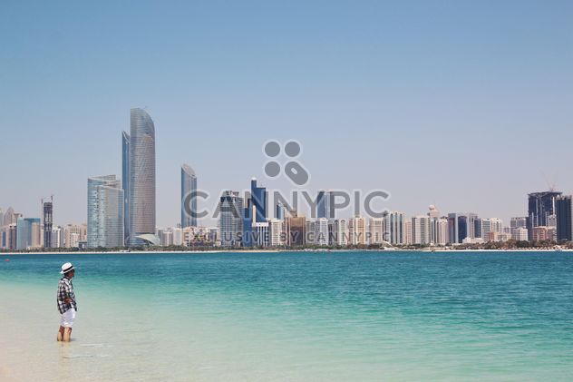 Man on beach and beautiful cityscape - Free image #344509