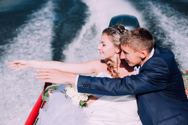 Happy wedding couple in boat on lake - image #345109 gratis