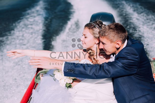 Happy wedding couple in boat on lake - image #345109 gratis