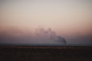 Landscape with smoke in field at sunset - image #346299 gratis