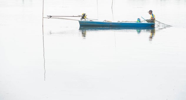 Fishermen in fishing boat on river - бесплатный image #347279
