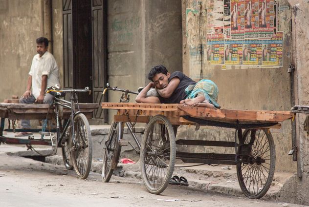 Man sleeping on bike with cart - image #452289 gratis