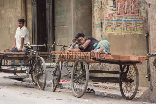 Man sleeping on bike with cart - image #452289 gratis