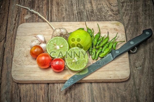 Lime, vegetables and knife on wooden cutting board - Free image #452419