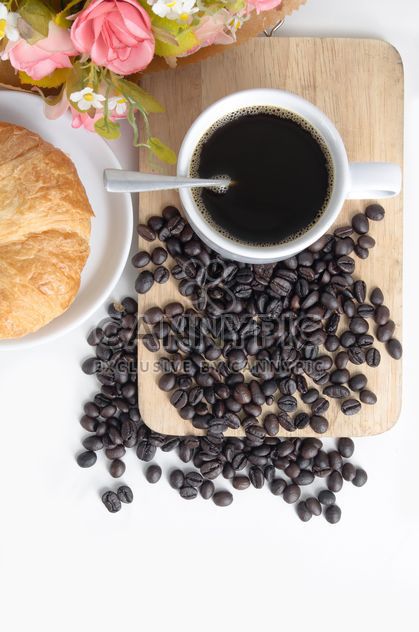 Cup of coffee with croissant, flowers and coffee beans - бесплатный image #452569