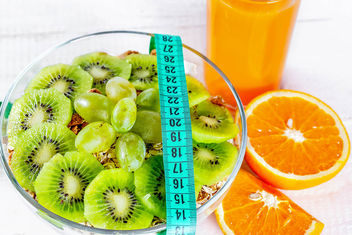 Proper diet for health and a beautiful figure-porridge and orange juice with measuring tape - image gratuit #456789 